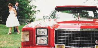 Mloda-para-w-tle-z-czerwonym-oldskulowym-samochodem